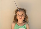 A young child wears a unicorn horn.