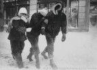 3 people walking in a blizzard.