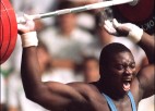 A weight lifter throws 484 pounds behind his head during  a clean-and-jerk.