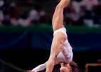 A gymnast performs on the balance beam.