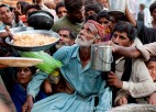 A Pakistan man holds on with all his strength as flood victims get evacuated by the Pakistan Navy.