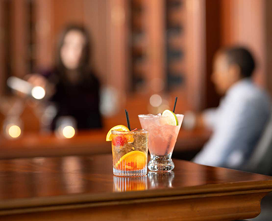 Mixed cocktails on a bar with blurred people in the background