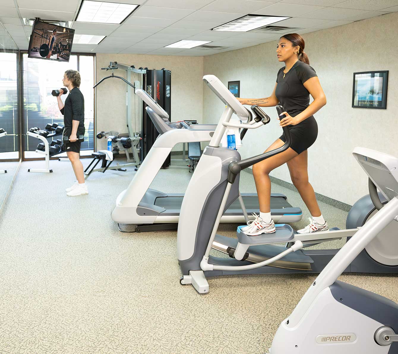 Fitness room with cardio equipment and a few dumbbells