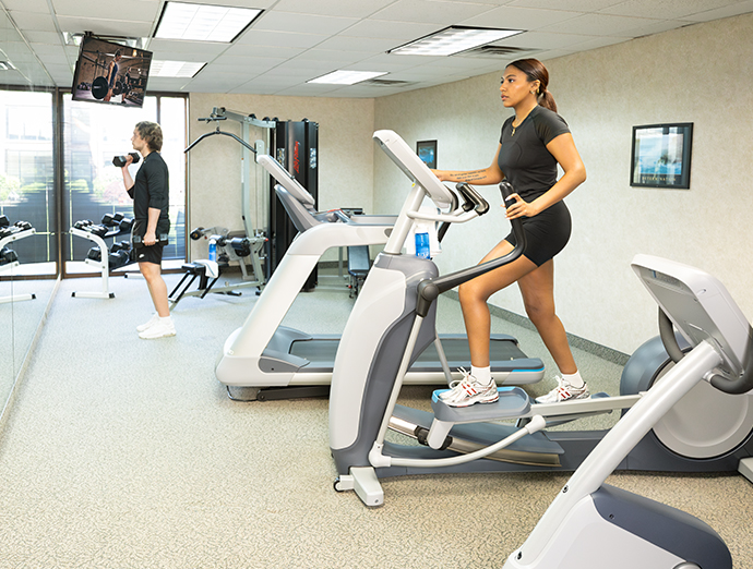 Fitness room with cardio equipment and a few dumbbells