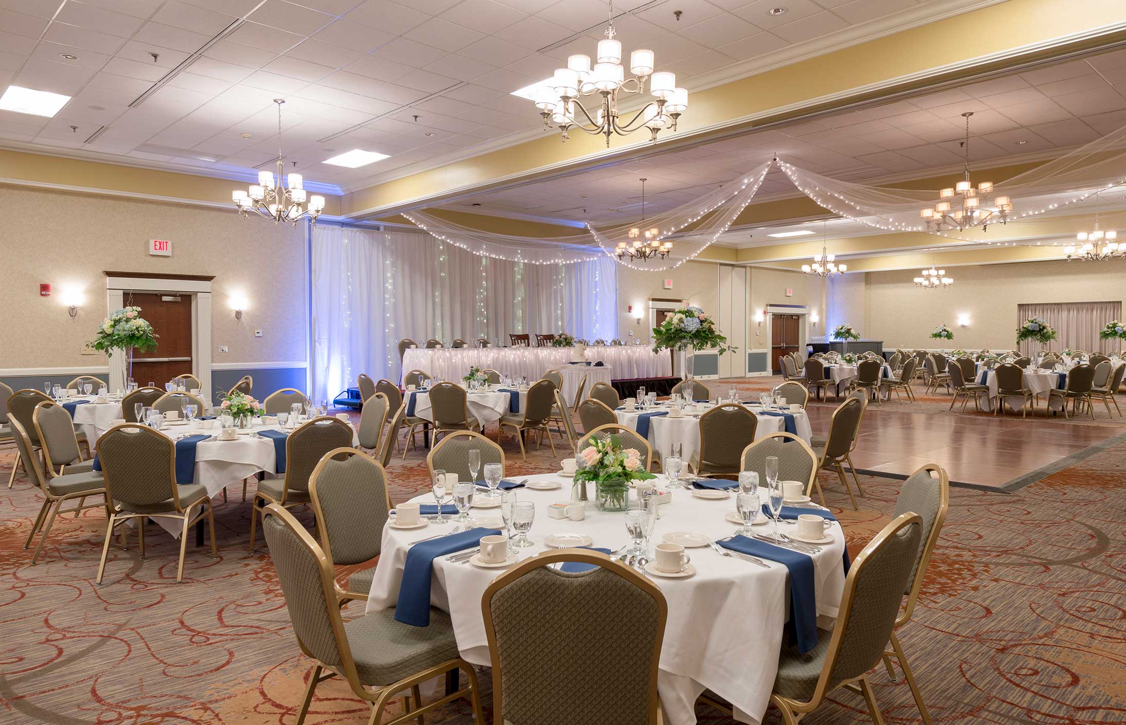 Wedding room setup with circular tables and chairs