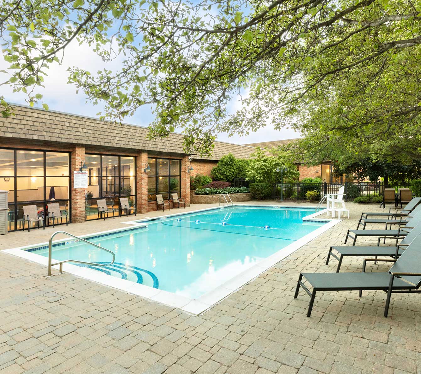 Outdoor pool with pool chairs lining the sides