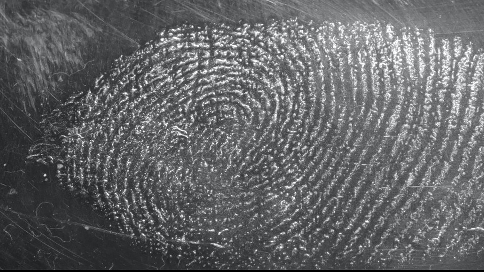 Grey fingerprint on a black glass type background