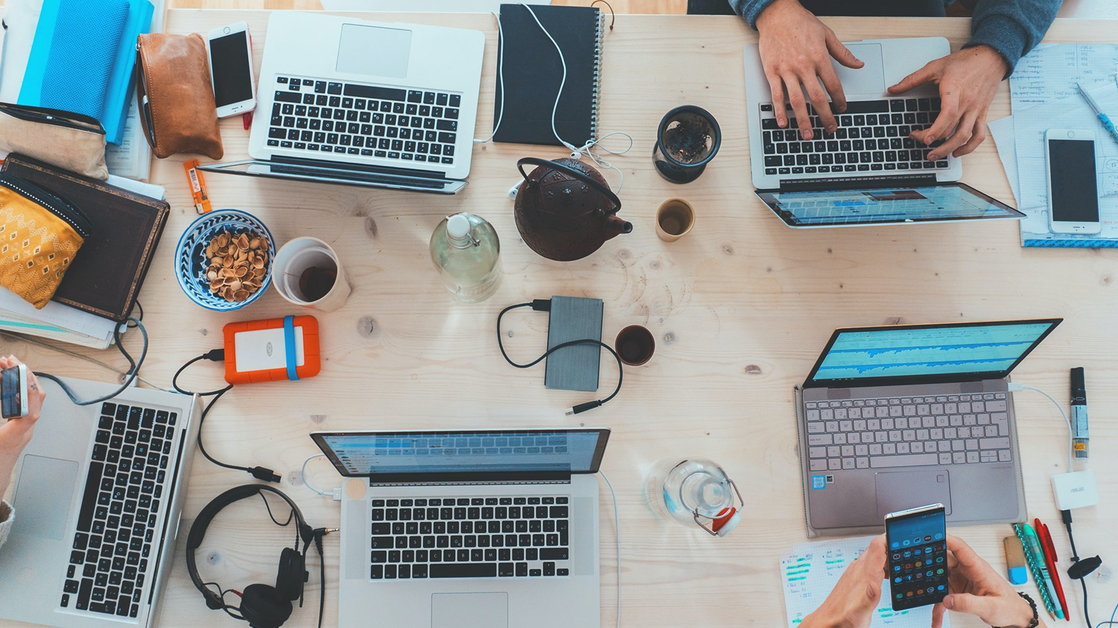 group of people using laptops and mobile phones at a table