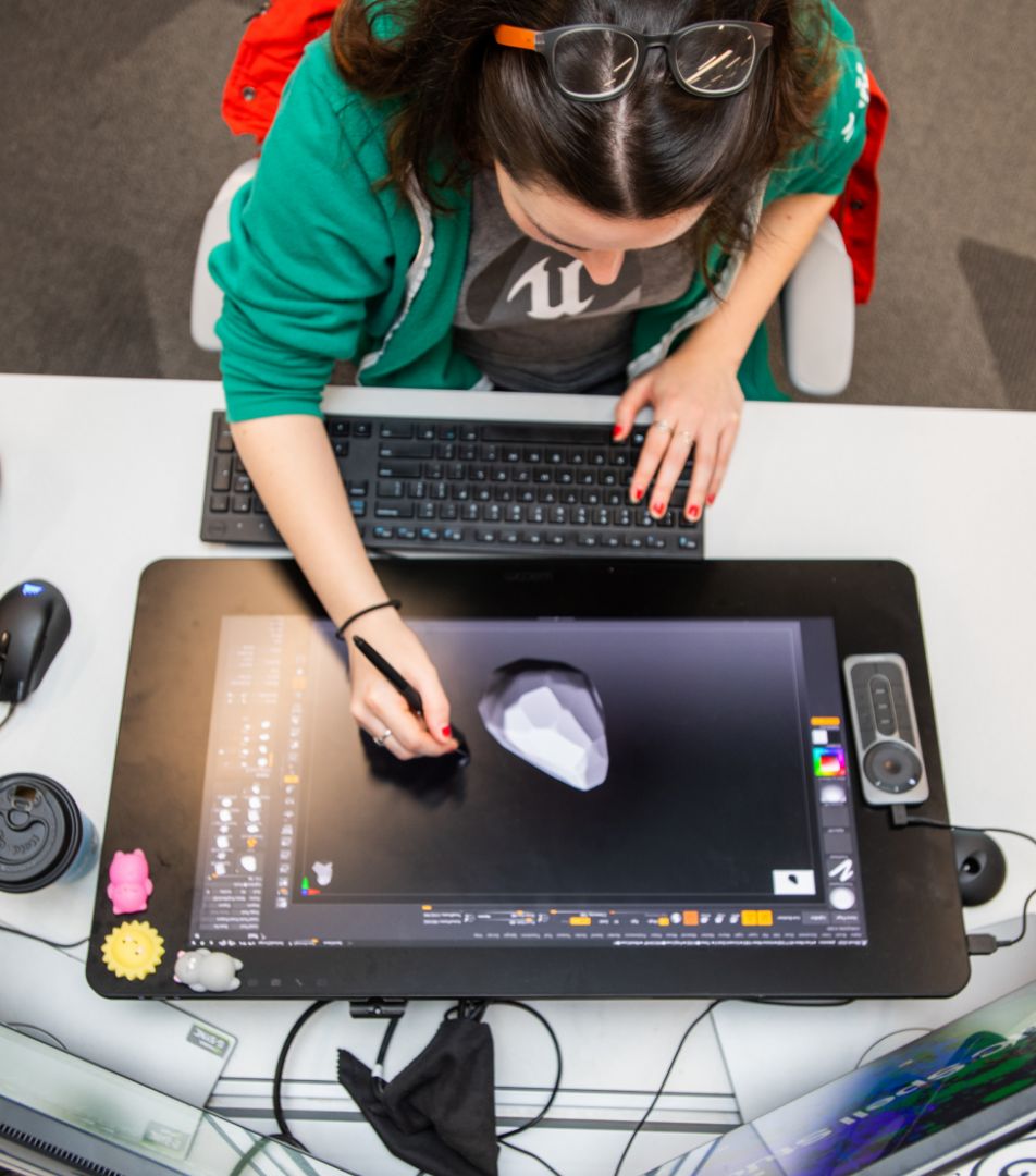 Overhead view of someone using 3D modeling software on a tablet