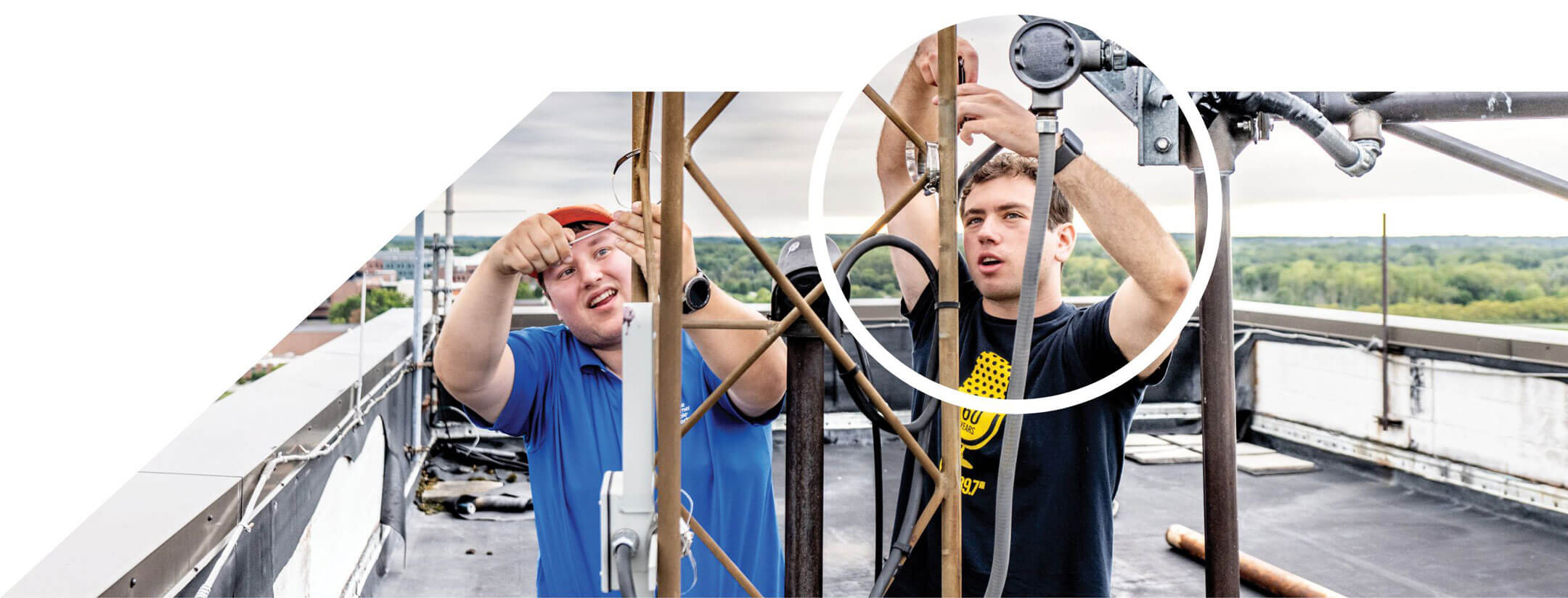 Alex Polge, left, and Remy Rattner working on WITR's broadcasting tech on top of Mark Ellingson Hall.