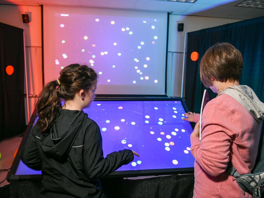 Two people using a demo that looks like star constellation