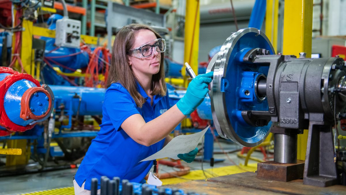 A student working with mechanical equipment in a hands-on co-op setting.