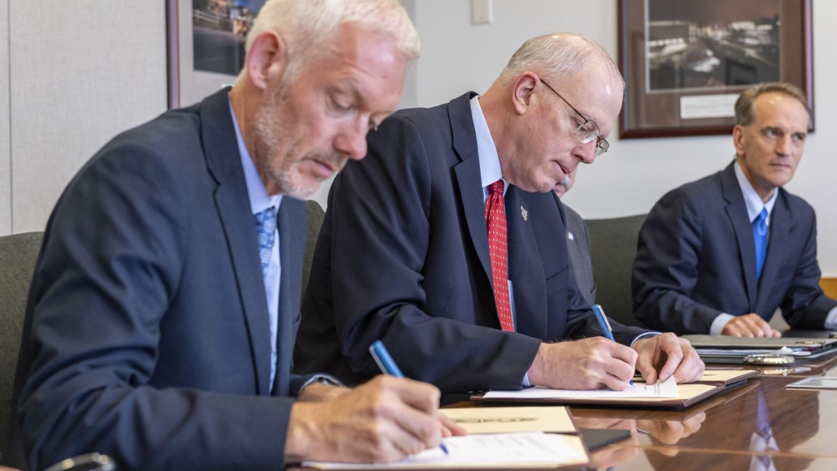 A formal meeting where participants are signing agreements.