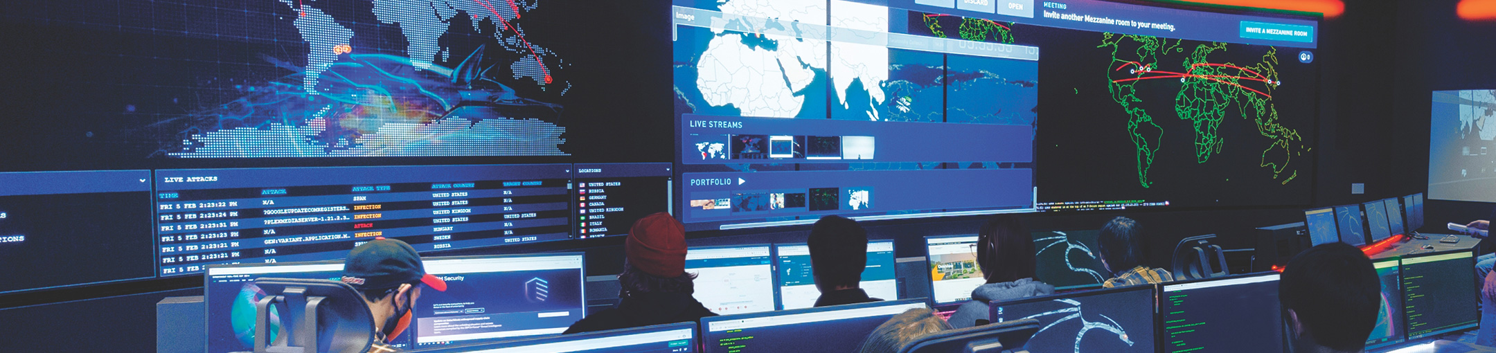 Computer room with large dashboards and multiple screens.