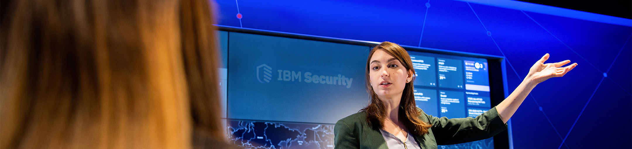 Allison Ritter standing in front of a blue wall and screens