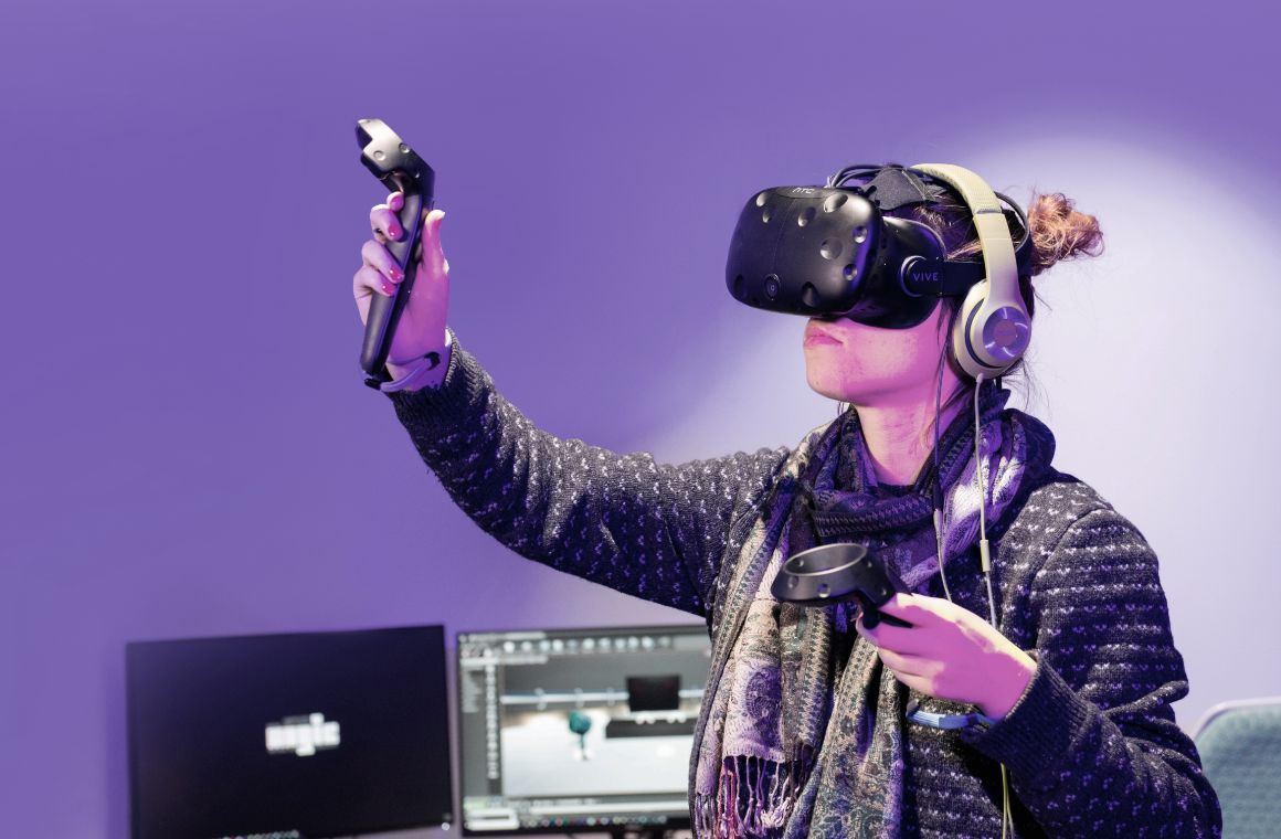 Person wearing a scarf using VR goggles and controllers