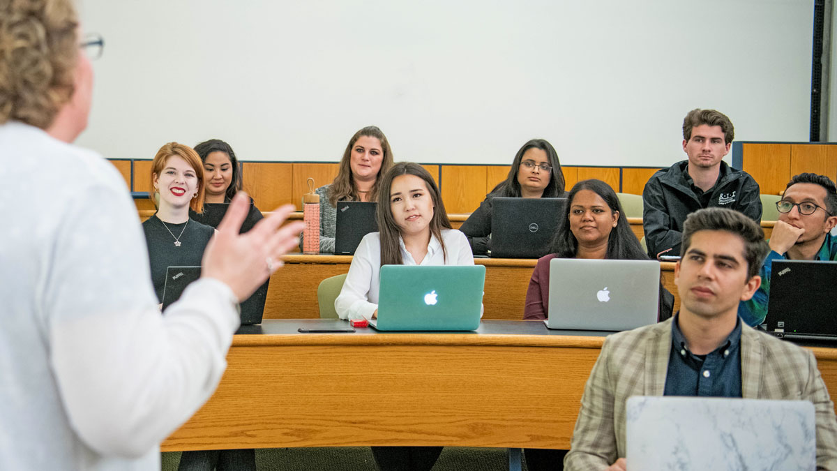 Students in a classroom looking forward at professor.