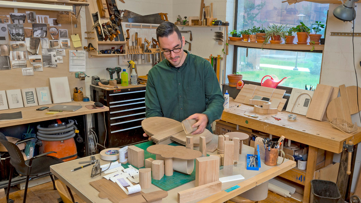 Man holds pieces of wood in a wood studio.