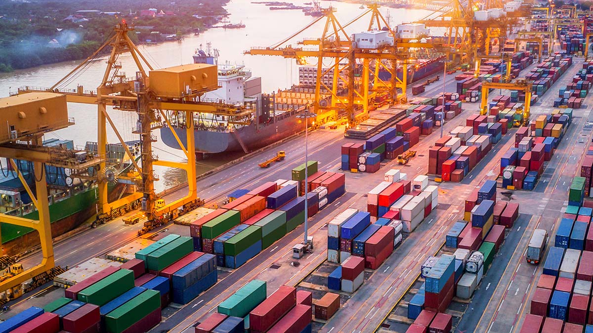 An aerial photo of a shipping yard with many different colored shipping containers.