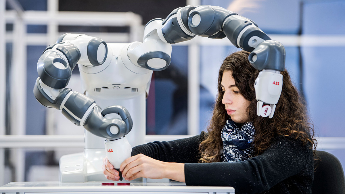 A student works with a robotic arm device.