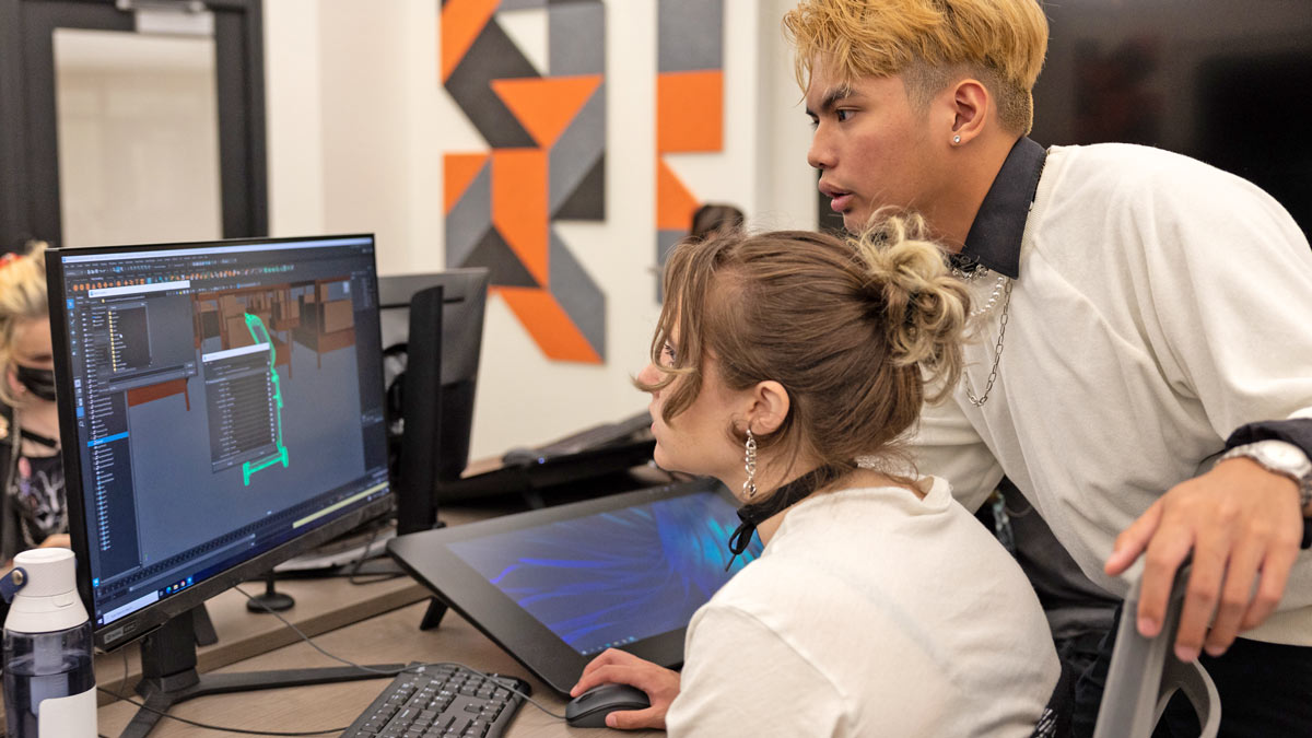 Two people in a lab looking at a computer.