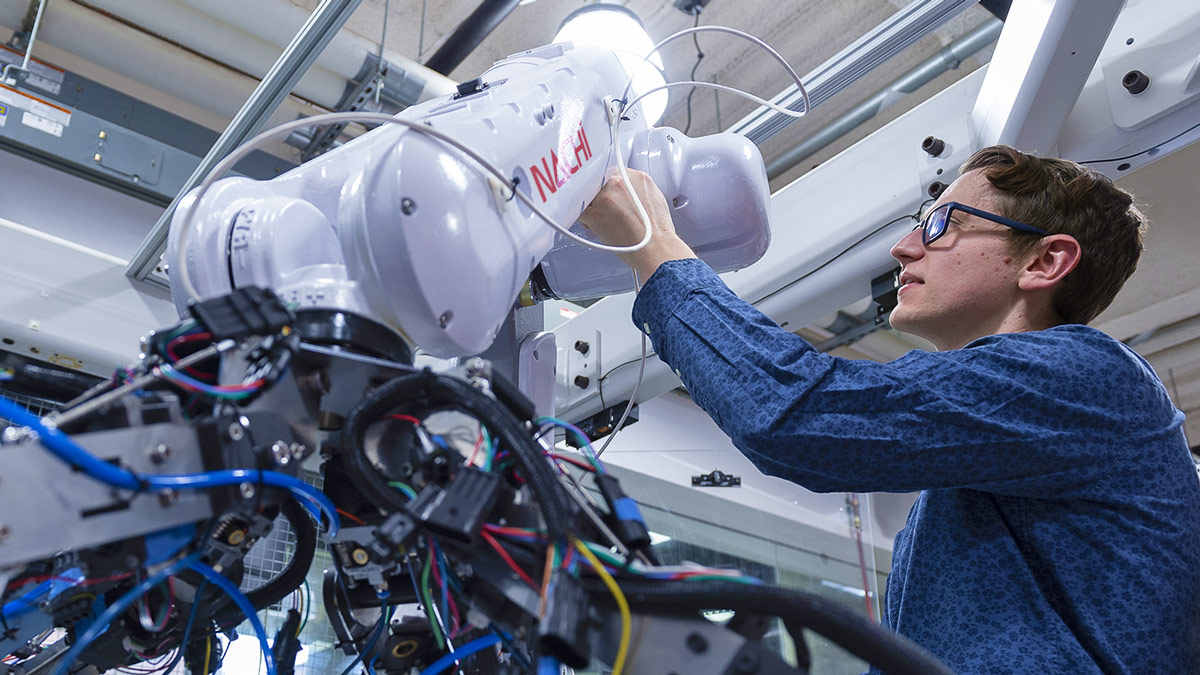 Student working on a large robotic arm.