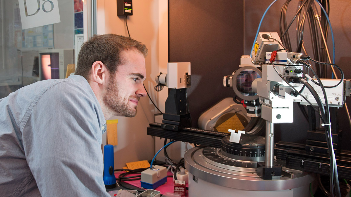 A student inspects an optical device.