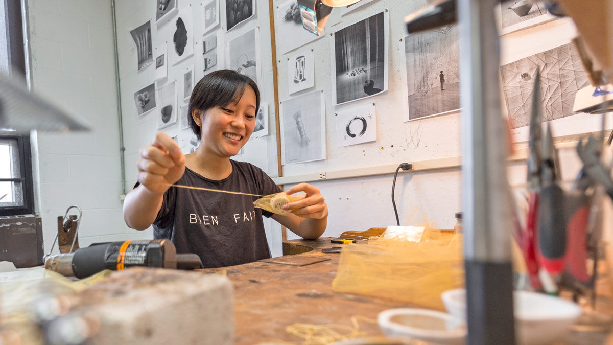 A student works on a jewelry project in a workshop.