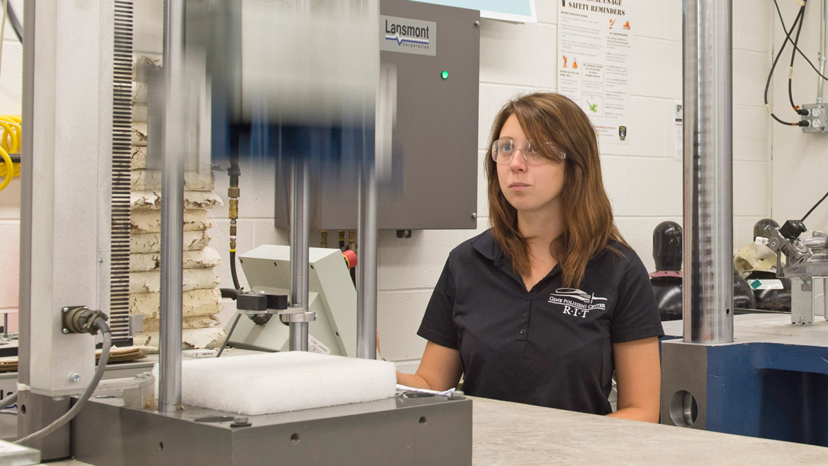 A student works with packaging equipment in a lab.