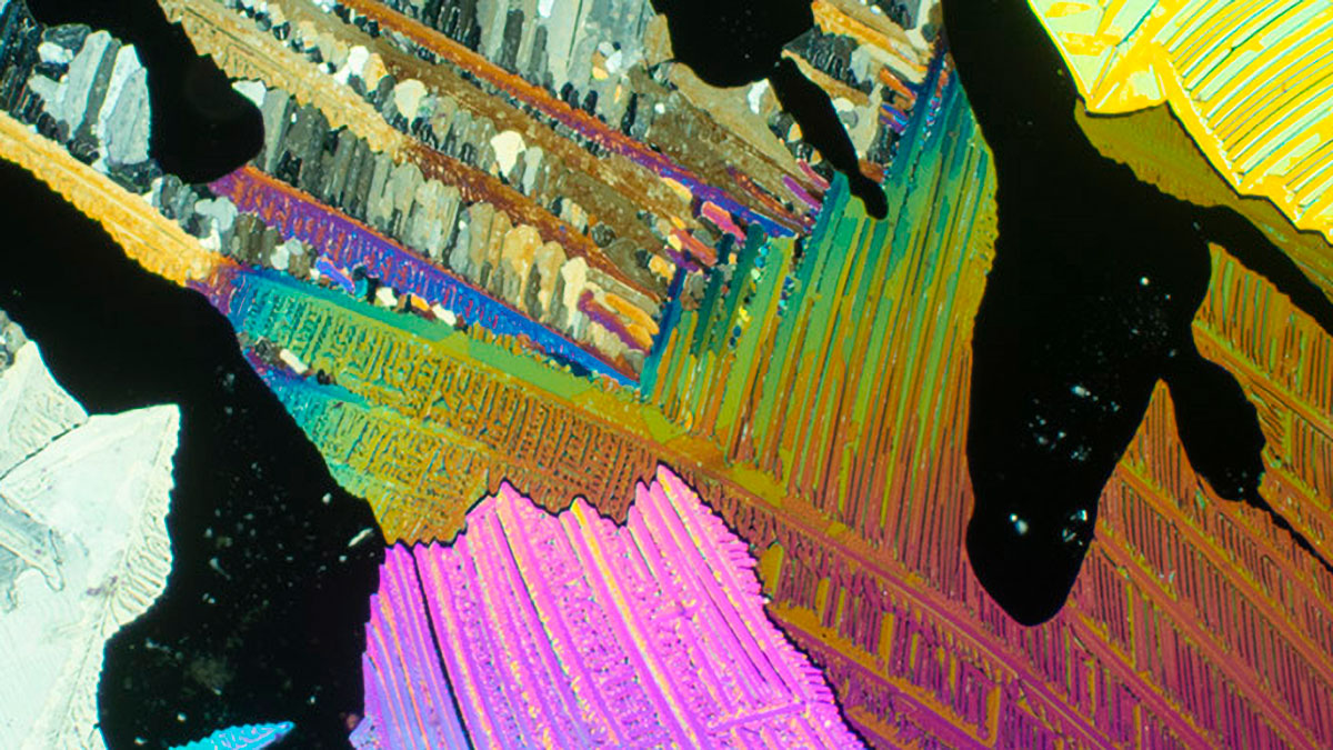 Microscopic close up of some sort of rainbow-colored element.