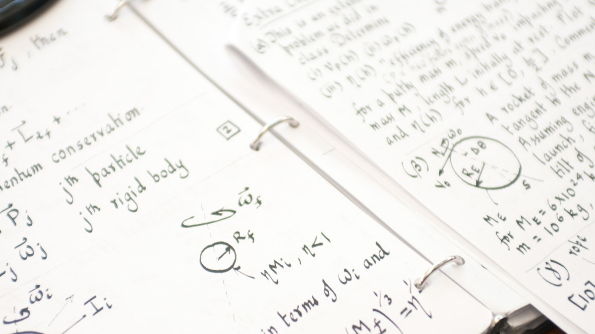 Close up of a 3-ring binder opened to written notes and formulas.