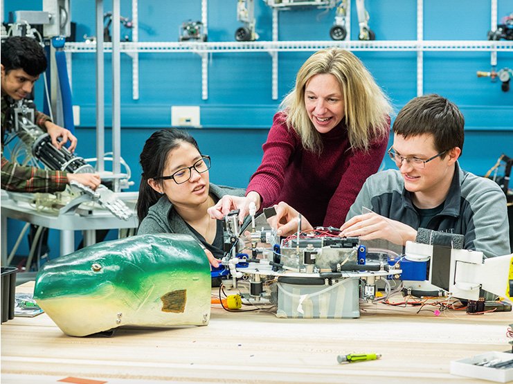 People standing around a robotic fish