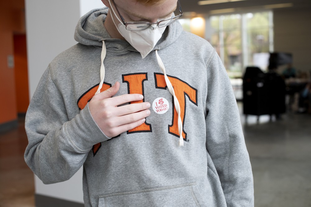 Student wearing mask touching sticker
