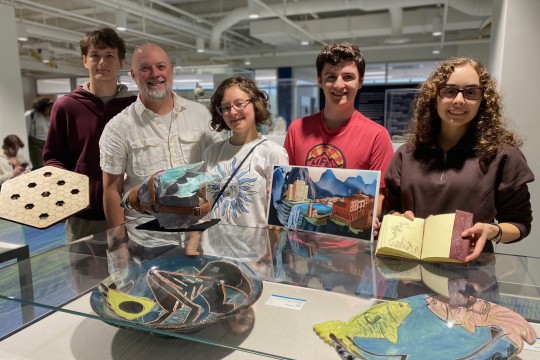 a photo of trent and students holding worldbuilding artifacts