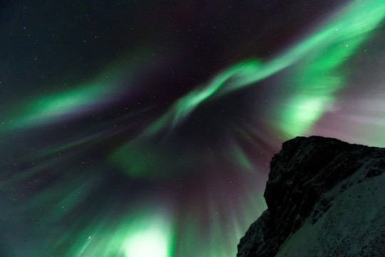 'the aurora borealis is shown with green and purple lights.'