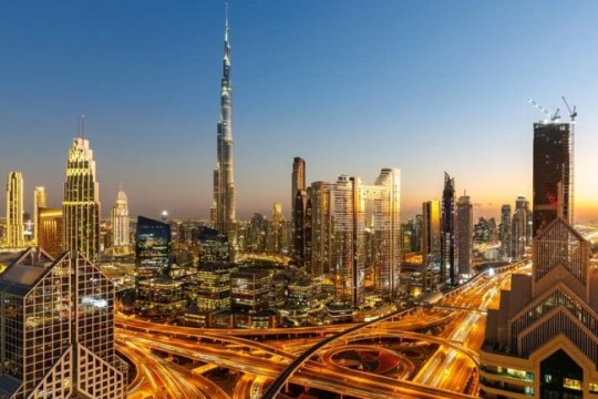 the skyline of Dubai is shown in early evening.