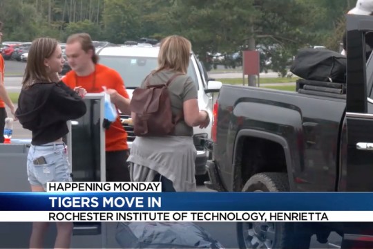 'people unload a students belongings from a black pickup truck.'