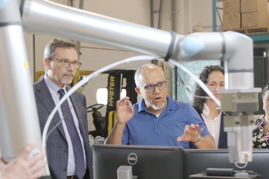 'Stephen Hammer and Andel Koester explains a robotic arm used for textile recycling.'