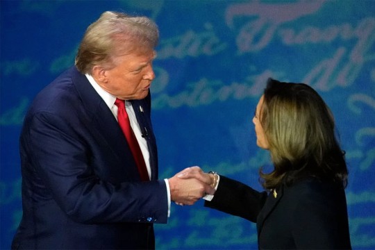 Former president Donald Trump stands to the left shaking hands with 2024 democratic nominee Kamala Harris on a debate stage.