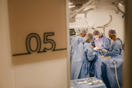 doctors work on a patient in a surgical suite.