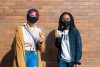 Two students stand in front of wall with RIT cookies