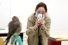 Student photographs bird with cell phone.