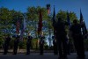 members of the U.S. Armed Forces stand holding american flags in vigil.