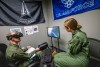 Two R O T C cadets sit in a small room. One has an A R device on their head while the other looks at them.