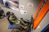 An R O T C cadet sits in a gaming chair with an A R device on their head.