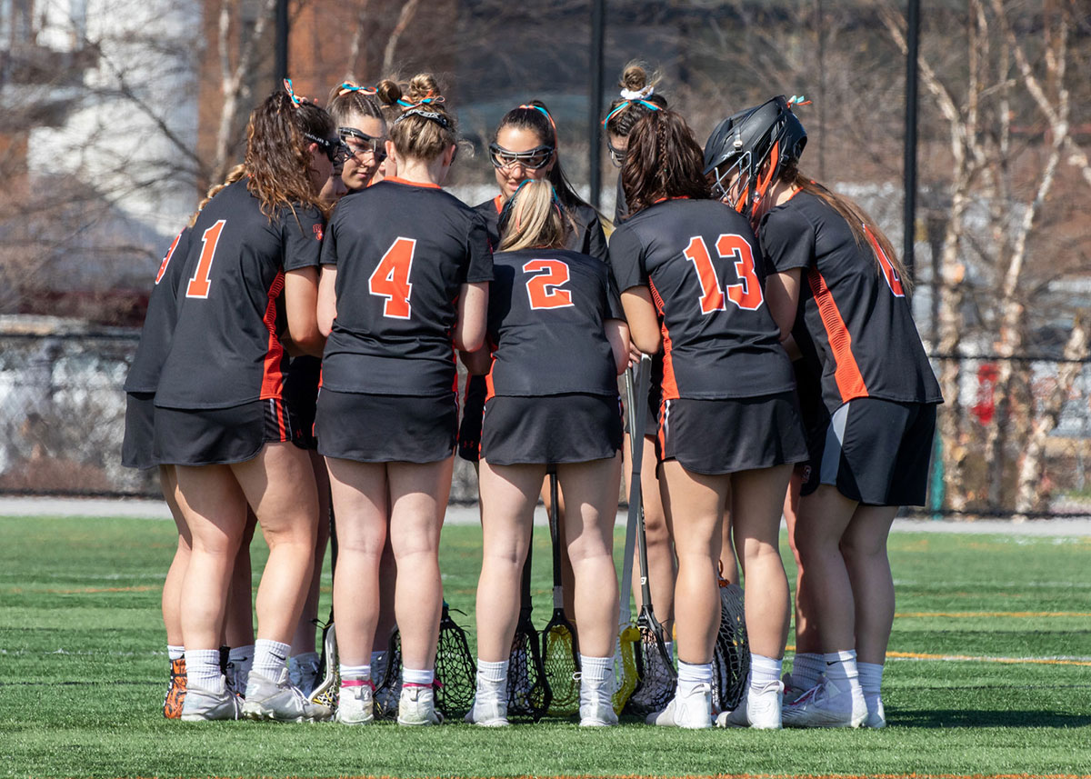 the RIT Women's lacrosse team huddled together