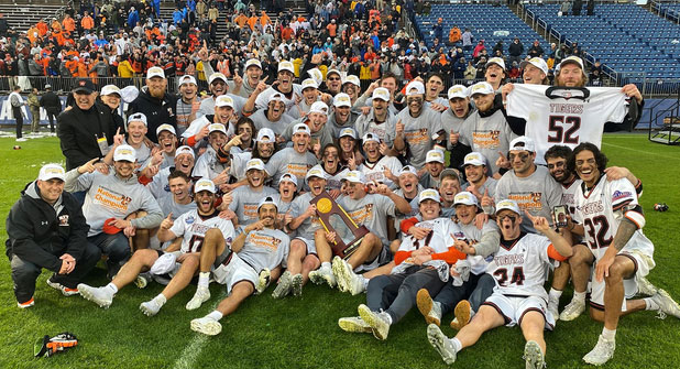 the RIT men's lacrosse team celebrating together on the field