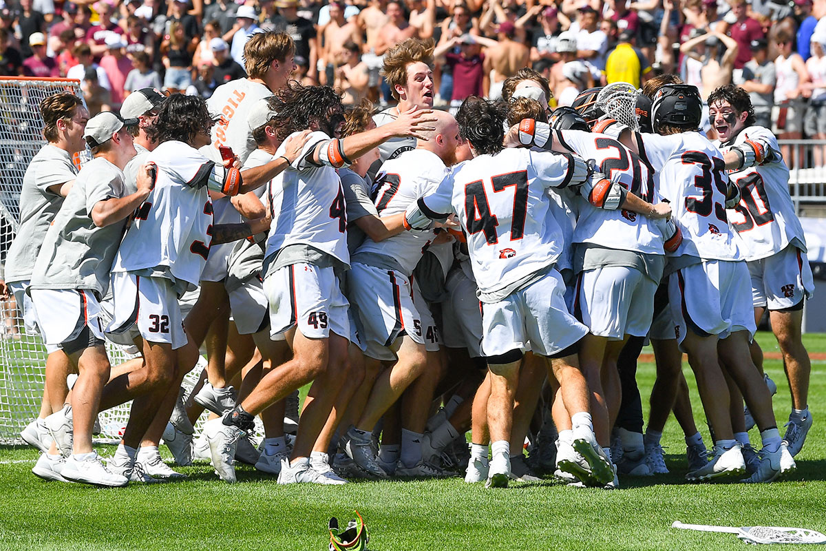 a lacrosse team celebrating on the field