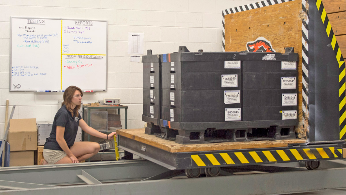 A student sits in front of a palette of boxes.