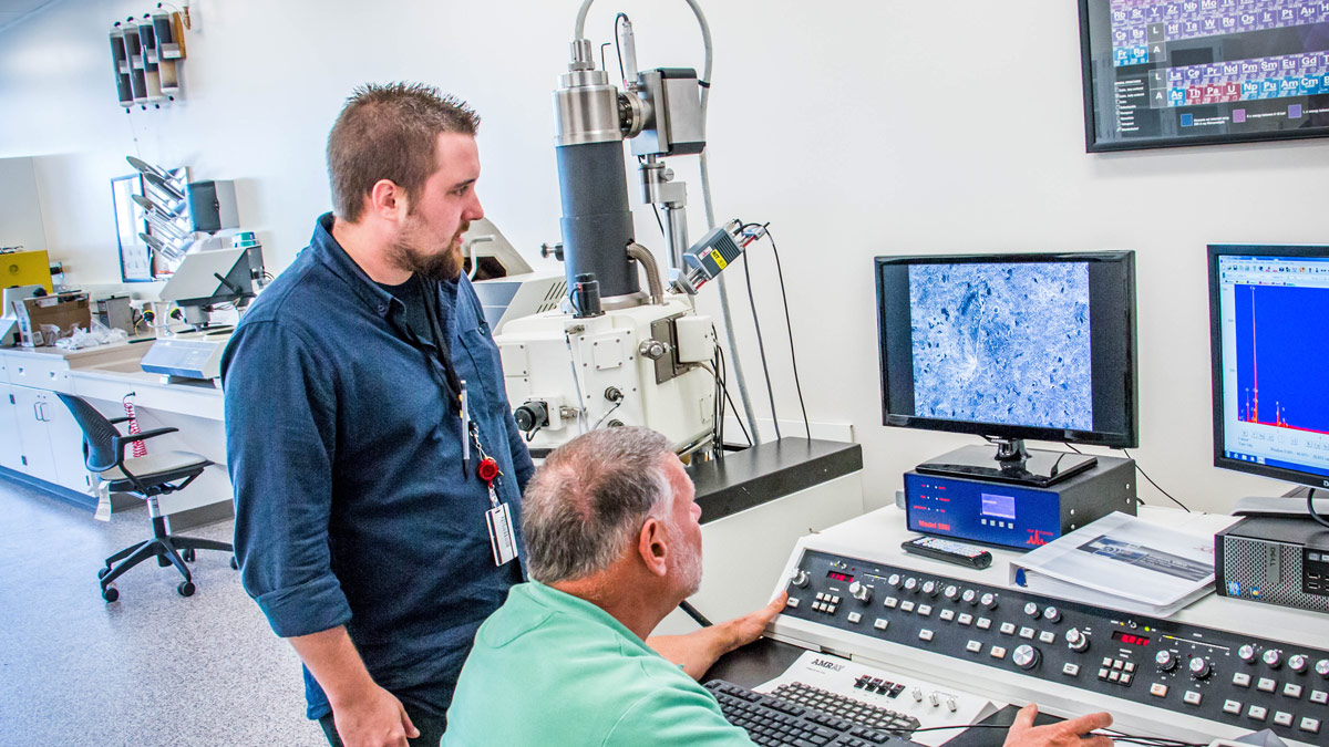 Two researchers working with a scanning electron microscope.